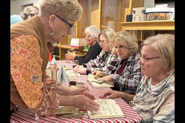 Instructor Jeanne Bowron (left) helps Elaine Hemme get started with a hymn book. Also pictured (front to back) are Joan Kindt, Peggy Fransman and Deone Hemme. Lori Sorenson/Rock County Star Herald Photo