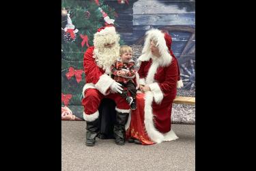 Kayden Brands isn’t happy about his moment with Santa and Mrs. Claus (Bryce Niessink and Janice Fick). Lori Soreson/Rock County Star Herald Photo