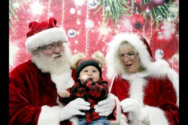 Jasiah Natte (center) looks to the camera as Santa and Mrs. Claus get ready for the taking of a Christmas picture. Mavis Fodness/Rock County Star Herald Photo