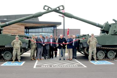Completing the cutting of the ribbon for the Luverne Readiness Center are (in the front row) Lance Ripka (standing at attention) Lt. Col. Adam Riedel, U.S. Rep. Brad Finstad, retired Maj. Gen. Richard Nash, Sen. Bill Weber, Brevet Colonel Warren Herreid, Luverne Mayor Pat Baustian, Rep. Joe Schomacker and (standing at attention) Bo Ilse. Mavis Fodness/Rock County Star Herald Photo
