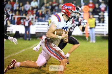 Greg Hoogeveen photo/HBCFB1 Patriots junior Brodie Metzger surveys the field with ball in hand against Edgerton Friday, Oct. 9. Metzger rushed for 141 yards and one touchdown in Edgerton. Hills-Beaver Creek beat the Flying Dutchmen 28-14 in the annual Red Rock game. H-BC is now 6-0 for the season.