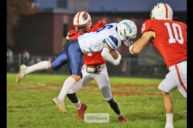 Greg Hoogeveen photo/LHSFB1 LHS senior Darius Dolo knocks a Minnesota Valley Lutheran player into the air with senior Coy Thone, No. 10, covering the tackle. The Cardinals beat the Chargers 56-25 at home Oct. 9.