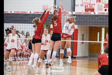 Greg Hoogeveen photo/0924LHSVB1 Cardinal senior Lexi Braun spikes the ball toward two Redwood Valley players at home Sept. 15 in Luverne. LHS fell 3-0.