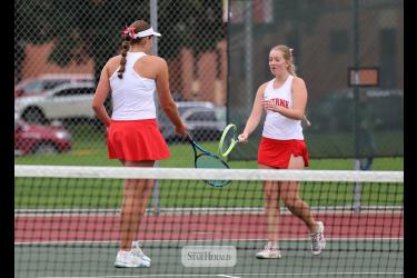 Greg Hoogeveen photo/LHStennis1 Sophomores Gracyn Woodley, left, and Lilly Lanoue tap rackets after scoring a point against Lincoln Tuesday, Sept. 22, at home. The duo won two sets in No. 1 doubles play