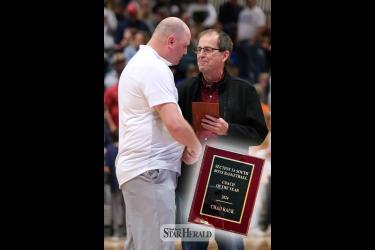 Loren Carlson from the Sub Region 10 Coaches Association, right, presents H-BC boys’ basketball head coach Chad Rauk with the 2024 Section 3A South Coach of the Year plaque after the Section 3 - South Subsection Championship game against Russell-Tyler-Ruthton on March 9 in Marshall.