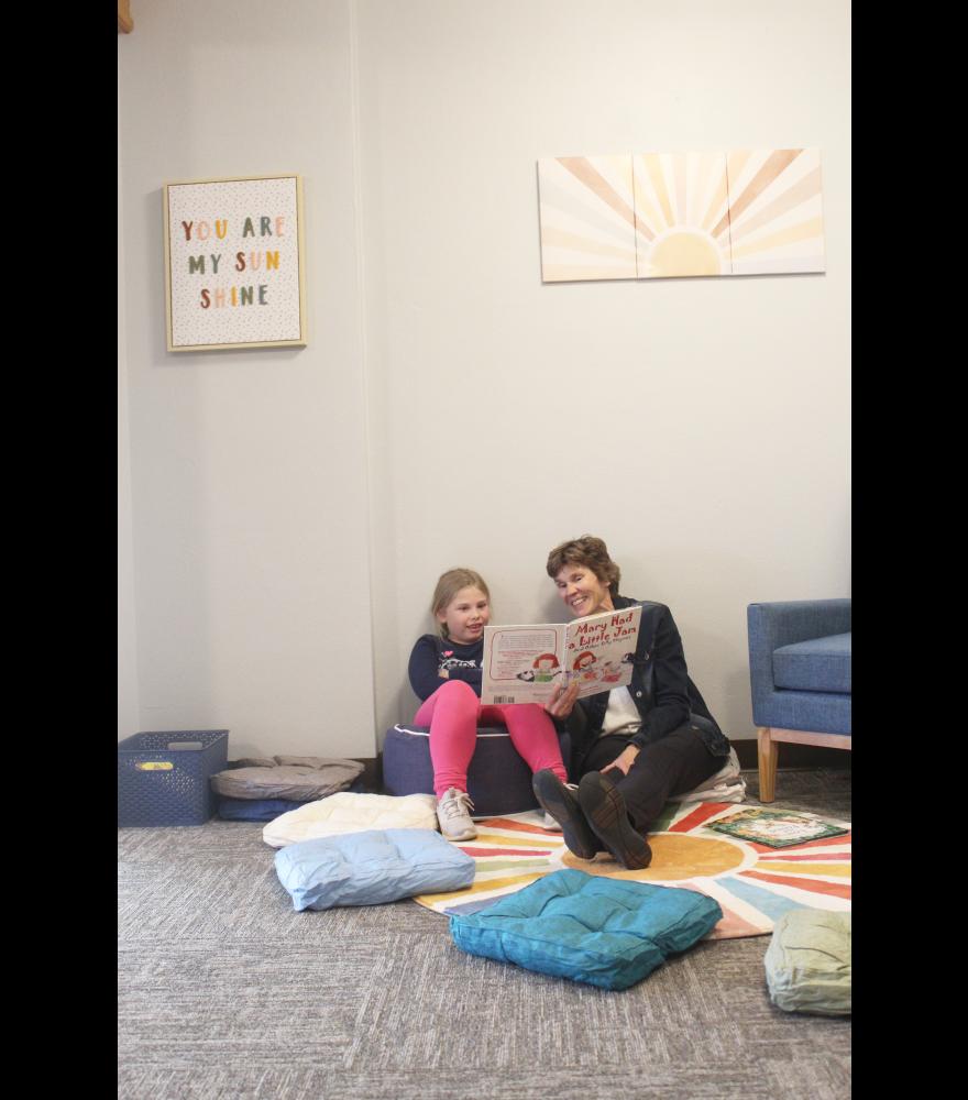 First-grader Anna Beyer (left) chooses a cozy corner at Grace Lutheran Church to read a book with Grace Reading Buddy Lisa Lundgren, a retired elementary school teacher.