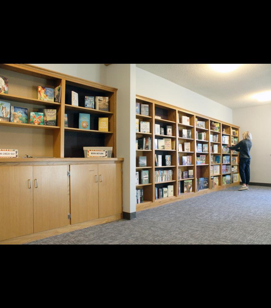 Jill Wagner straightens books in Grace Lutheran Church’s library, where she and other church members started Grace Reading Buddies. The buddies program pairs adult volunteers and elementary-aged children together to read twice a week in an effort to instill a love for reading in the students.