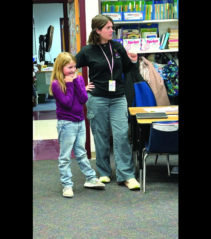 CLIMB Theatre actress Kirsten Erickson and third-grader Nora Sheppard illustrate how body language can send a message about brain health.